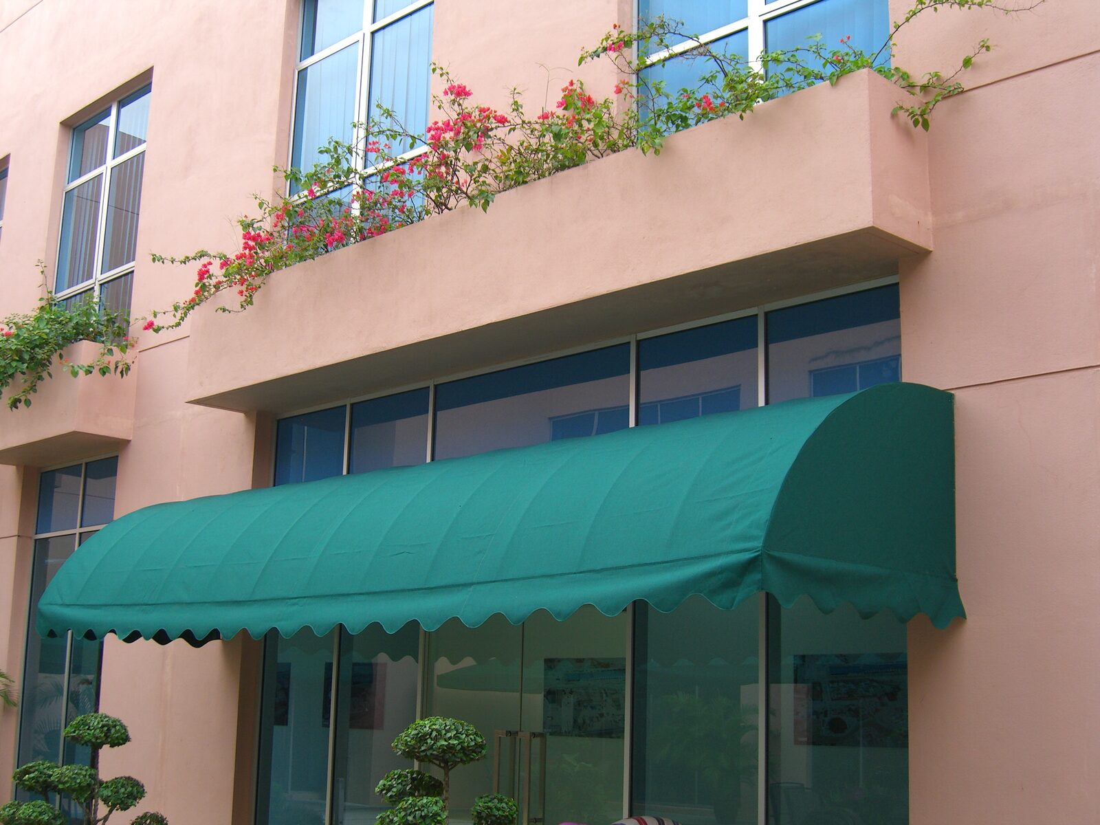 Teal curved fixed canopy over shop windows in Malaysia
