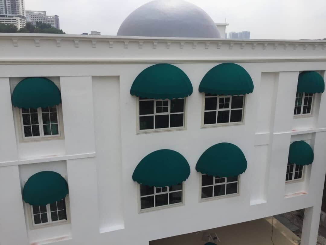 Row of teal domed fixed canopies over feature windows on a modern building