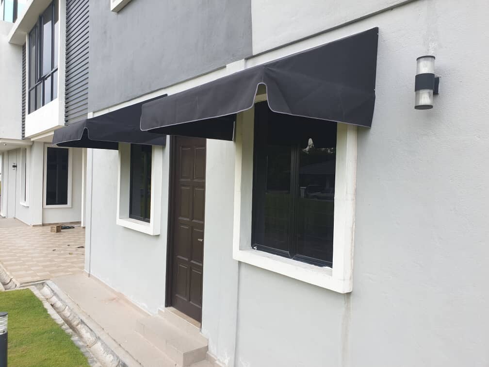 Charcoal fixed canopy awnings over the door and windows of a modern terrace home