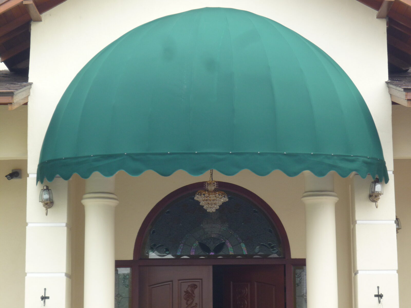 Round domed fixed canopy over a grand arched house entrance in Malaysia