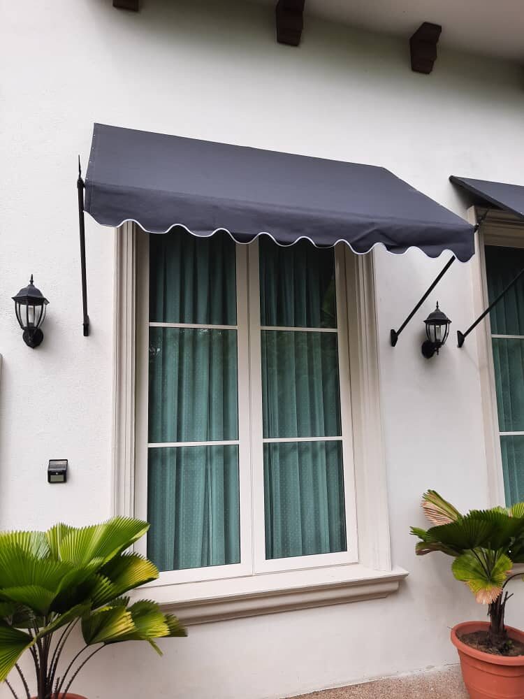 Charcoal scalloped fixed canopy over a window with carriage lamps